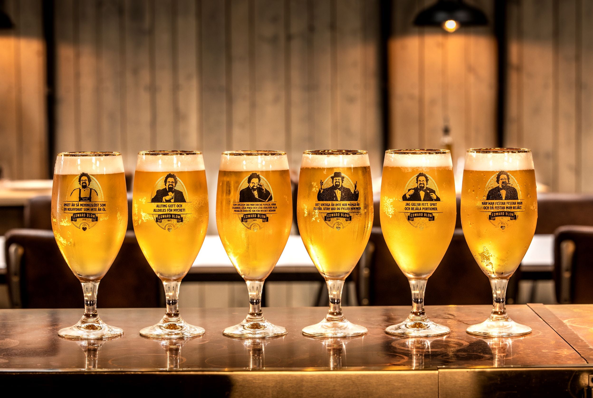 Ölglas, Med citat, Edward Blom, Framsida, Med omgivning, Flera glas brevid varandra på rad, Guld kantad topp, LIVET PÅ EN PINNE.