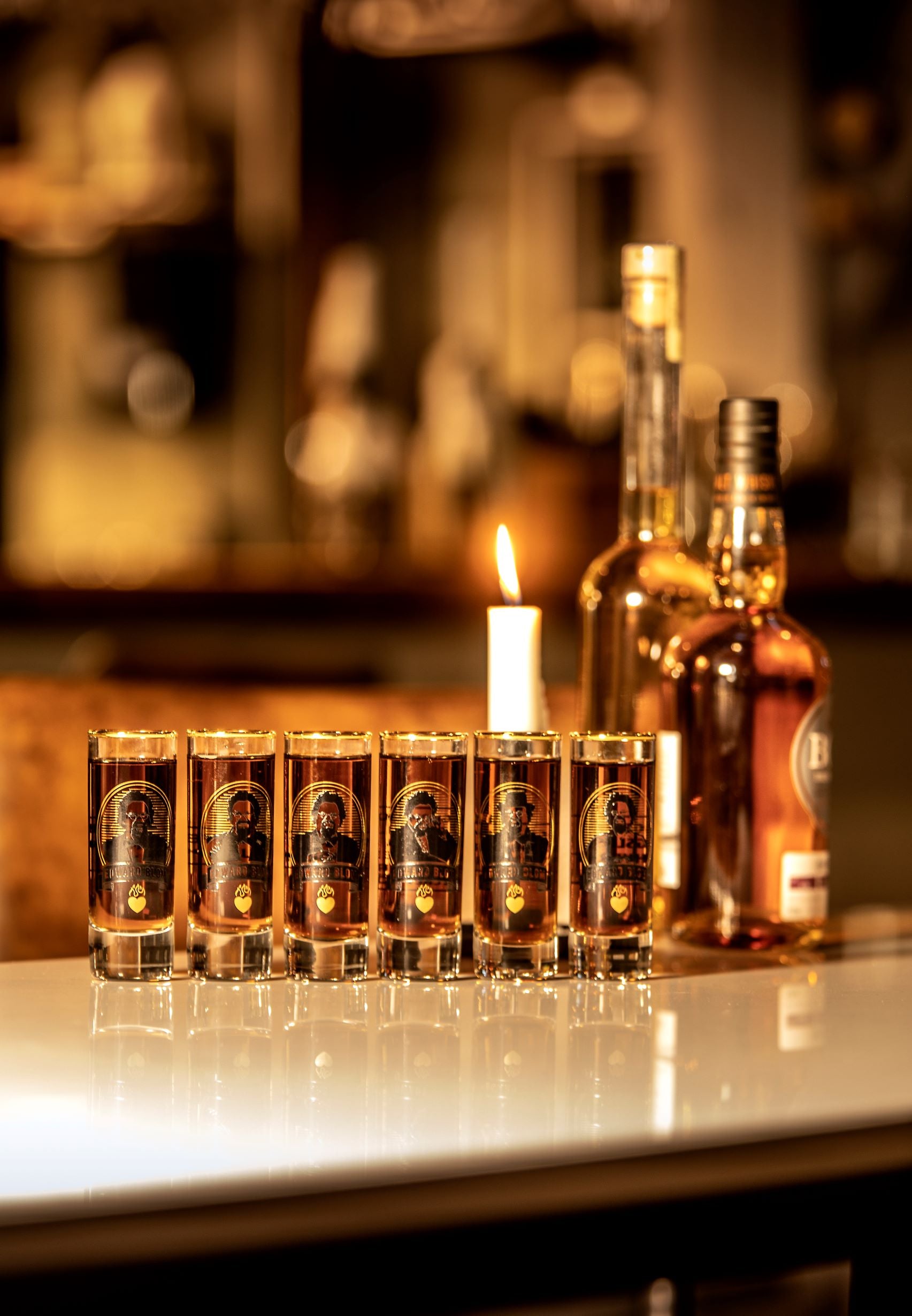 Shotglas, Med citat, Edward Blom, Framsida, Flera shotglas, Med omgivning, Med dryck i, Tänt ljus bakom glasen, Glasen står på ett bord